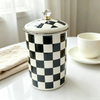 Glossy black and white checkered metal jar side view detail